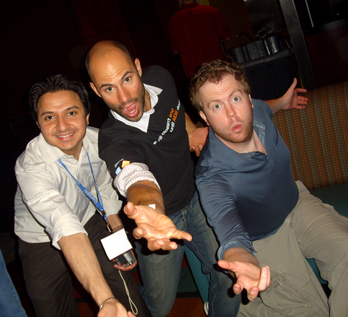 Three guys with their arms extended in a bowling pose and silly looks on their faces.